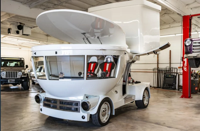 The Toilet Car with its lid closed, front three-quarter view in a garage