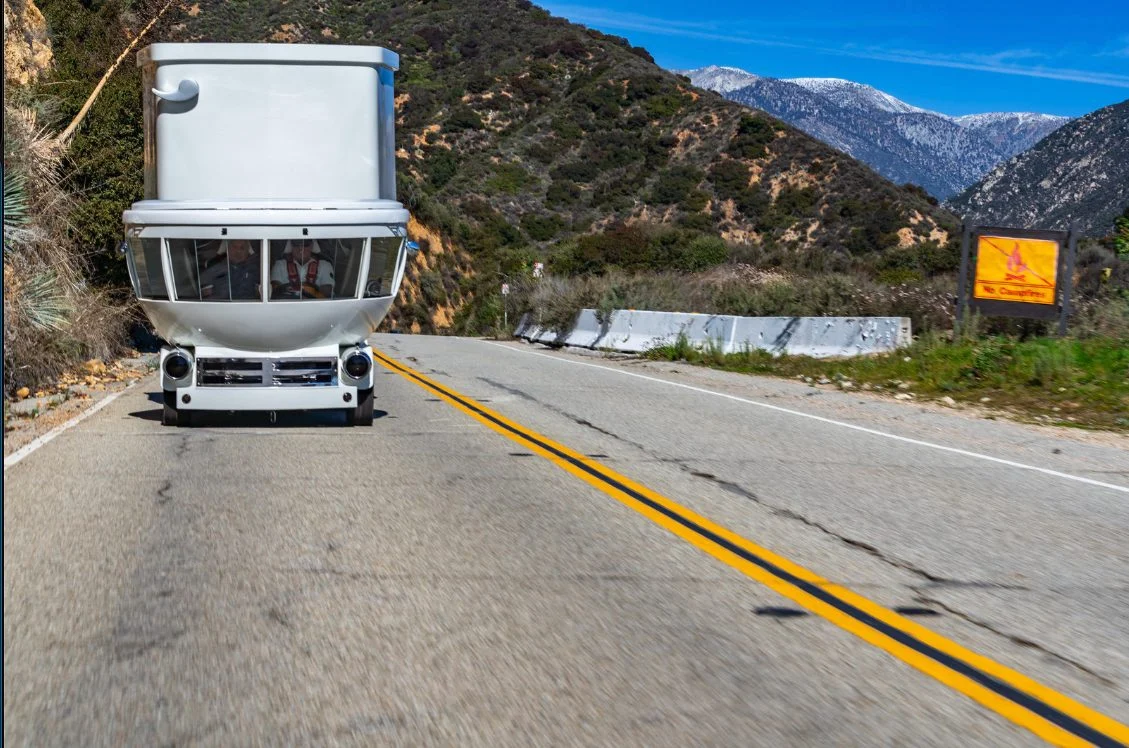 The Toilet Car driving head-on along a mountain road